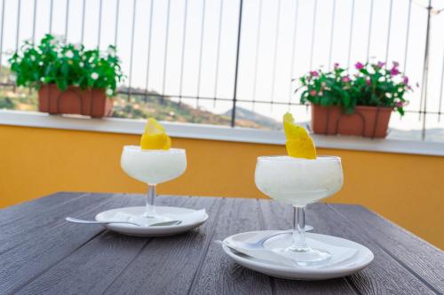 two wine glasses with ice cream on a wooden table at La Dimora Di Segesta B&B in Calatafimi