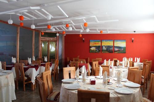 a dining room with tables and chairs and red walls at Alhambra Hotel in San Antonio