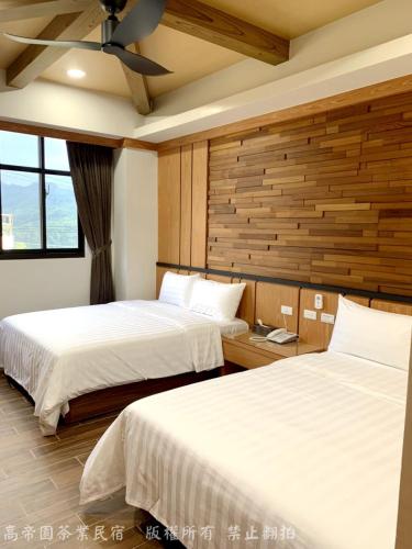 a bedroom with two beds and a ceiling fan at Gaodiyuan Tea B&B 高帝園茶業民宿 in Meishan