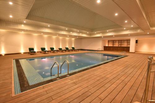 a large pool in a large room with chairs around it at Araliya Red - Budget friendly Hotel- Where you find stunning 360 panoramic view of Nuwara Eliya in Nuwara Eliya
