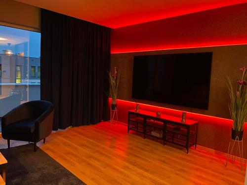 a living room with a flat screen tv and red lighting at VIP Apartament-Marine in Rumia
