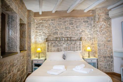 a bedroom with a large bed with two towels at Trapela Areopolis, Boutique Hotel in Areopolis
