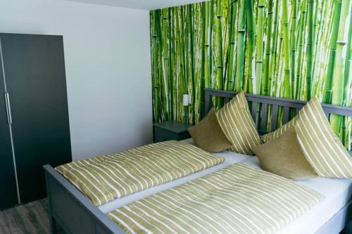 a bed with two pillows and a bamboo wall at Ferienwohnung Klink in Lieser