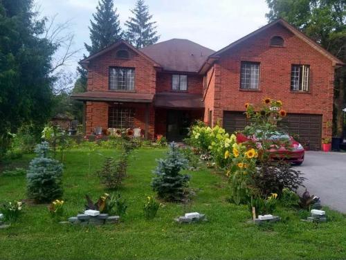 a brick house with a garden in front of it at Luxury Suites at Military Trail in Toronto