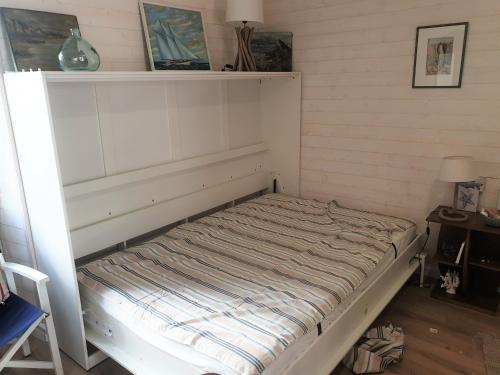 Ce lit se trouve dans un dortoir doté d'un mur blanc. dans l'établissement Ty West, à Batz-sur-Mer