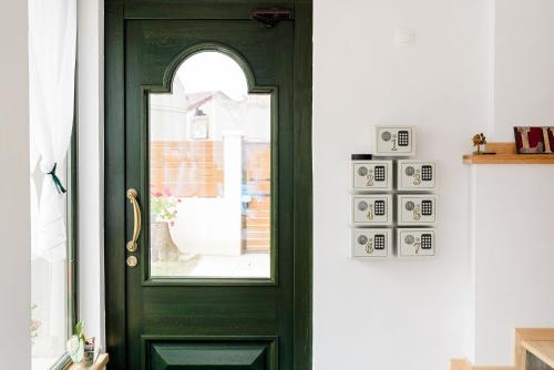 Una puerta verde con una ventana en una habitación en CHIC VOYAGE, en Sibiu