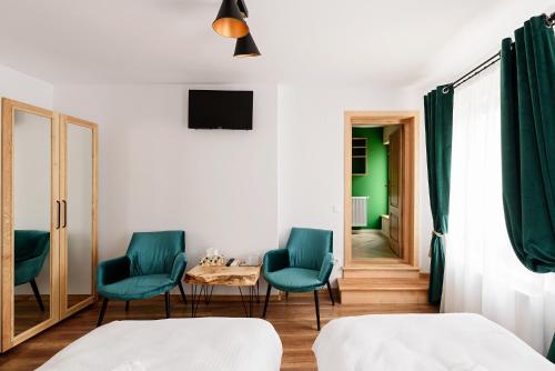 Una habitación con dos sillas y una mesa y un televisor. en CHIC VOYAGE, en Sibiu
