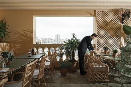 a man standing in front of a dining room table at Albergo Hotel in Beirut