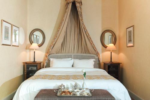 a bed with a white comforter on top of it at Albergo Hotel in Beirut
