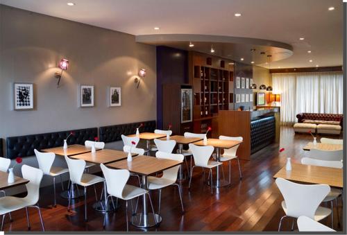 ブエノスアイレスにあるPalermo Suites Buenos Aires Apartmentsの木製テーブルと白い椅子が備わるレストラン