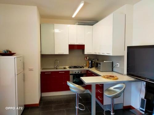 een keuken met witte kasten en een tafel met een pizza erop bij L'OLIVO appartamento turistico in Lucignano