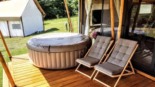 two chairs and a large barrel on a deck at Pálos Resort in Zalacsány