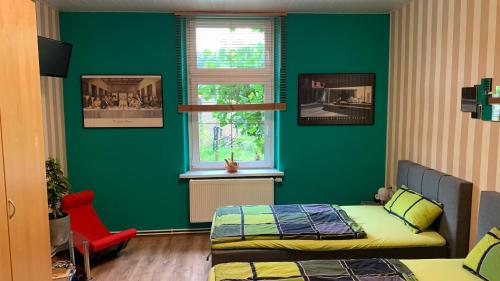 a green room with two beds and a window at YourHome-PM in Michendorf