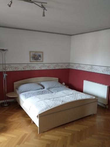 Schlafzimmer mit einem Bett mit einer roten und weißen Wand in der Unterkunft Ferienwohnung Madlene 2 in Gablitz