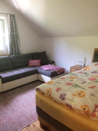 a living room with a couch and a bed at Appartement Döringerhof in Aich