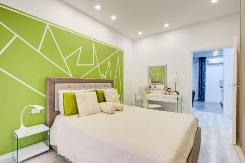 sypialnia z łóżkiem i zieloną ścianą w obiekcie CEJM Apartments Merano w Meranie