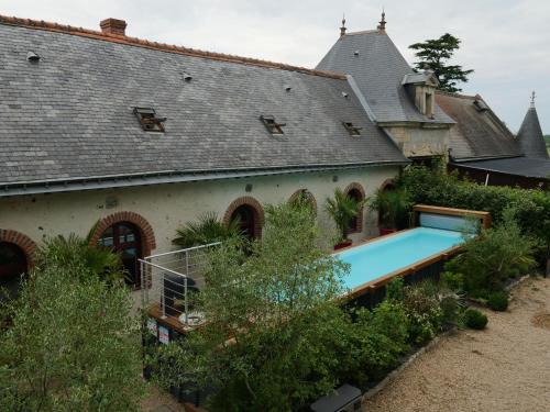 - une vue extérieure sur une maison avec une piscine dans l'établissement GITE LONGERE DE 15 PERSONNES AU CHATEAU DE JALLANGES VOUVRAY, à Vernou-sur-Brenne