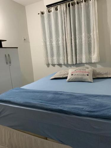 uma cama num quarto com uma janela com uma almofada em Apartamento bem localizado próximo ao DETRAN, Assembleia Legislativa de Cuiabá, Centro Político e Shopping Pantanal em Cuiabá