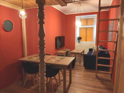 ein Esszimmer mit orangefarbenen Wänden sowie einem Tisch und Stühlen in der Unterkunft Centrum Apartament Szejka in Świdnica