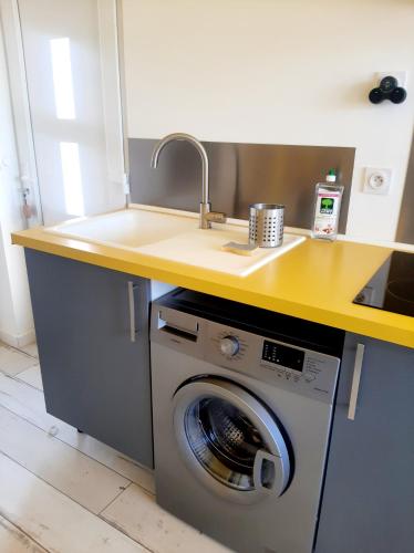 une cuisine avec un évier et une machine à laver dans l'établissement Le Paddle - station balnéaire Les Sablettes, à La Seyne-sur-Mer