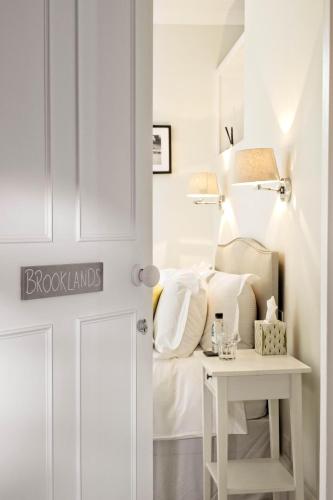 a door to a bedroom with a bed and a table at Saddlers B&B in Funtington