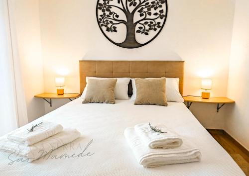 a bedroom with a bed with two towels on it at Casa Serra São Mamede in Alegrete