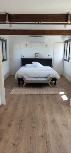 a bedroom with a bed and a wooden floor at Le Pigeonnier Spa du Panty Gîte rural de charme in Saint-Tricat