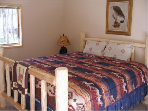 a bedroom with a bed with a wooden bed frame at Comanche Lodge in Custer