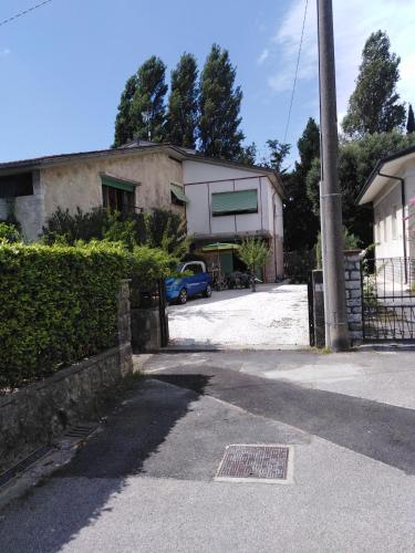 a house with a car parked in front of a driveway at Il semaforo Una o due camere matrimoniali con bagno a pochi passi dal centro Pietrasanta, con Wi-Fi in Pietrasanta