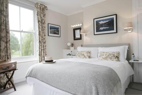 a white bedroom with a large bed and a window at Saddlers B&B in Funtington