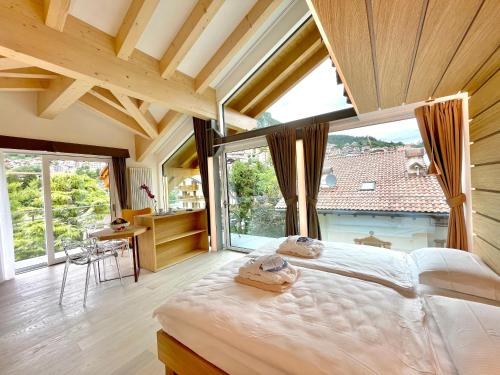 a bedroom with a large bed and a large window at Alledolomiti Boutique Lake Hotel - Adults friendly in Molveno