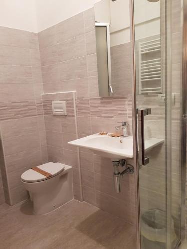 a bathroom with a toilet and a sink and a shower at Hotel La Torre in Cogoleto