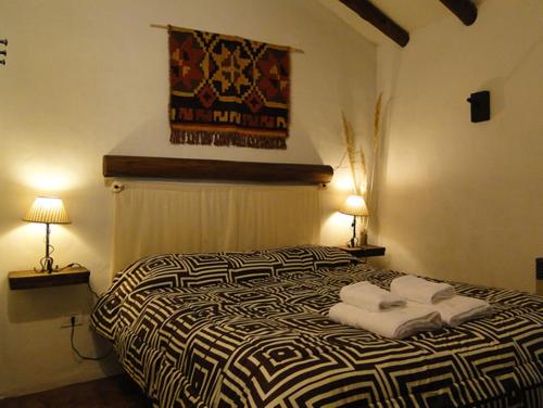 1 dormitorio con 1 cama con 2 toallas en Chalets, Cabañas Terramaría de Potrerillos en Potrerillos