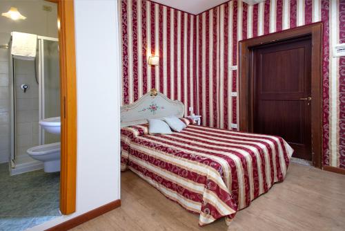 ヴェネツィアにあるLocanda Casa Martiniのベッドルーム1室(ベッド1台付)、バスルーム(トイレ付)