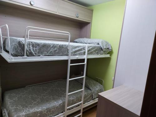 two bunk beds in a room with a ladder at Los Llanos de Escarrilla in Escarrilla