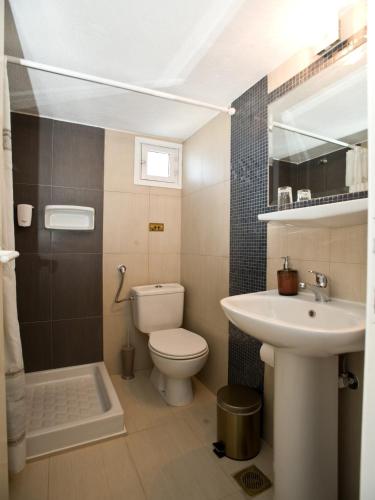 ein Badezimmer mit Toilette und Waschbecken in der Unterkunft Vana Holidays in Ornos