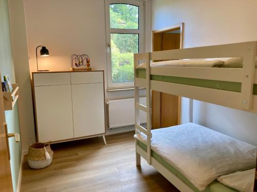 een kleine kamer met 2 stapelbedden en een raam bij Ferienhaus an der Seefahrtschule in Großefehn 