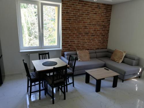 a living room with a couch and a table and chairs at Lipowa 22 Centrum Apartament in Białystok