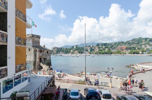 un gruppo di persone su una spiaggia vicino a un corpo d'acqua di LA CASA ROSA AL MARE- Vista mare- Centrale a 20 mt dal mare-Garage privato- aria condizionata-wifi a Rapallo