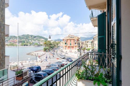 a view from a balcony of a city with cars parked at Alla Casa Rosa al Mare, Central Seafront Stay, Air Conditioning, Wi-Fi, the Ideal Choice for a Relaxing and Exciting Coastal Escape, with available on request at 20,00 euro per night Private Garage, Welcome kit Priority, Prosecco and Canestrelli in Rapallo