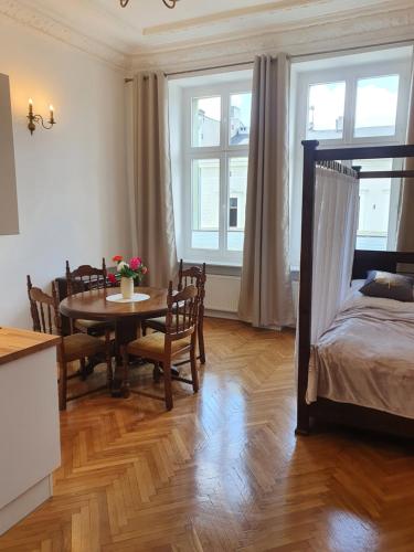 Pokój ze stołem i łóżkiem oraz stołem i krzesłami w obiekcie Prestige Aparthotel Piotrkowska w Łodzi