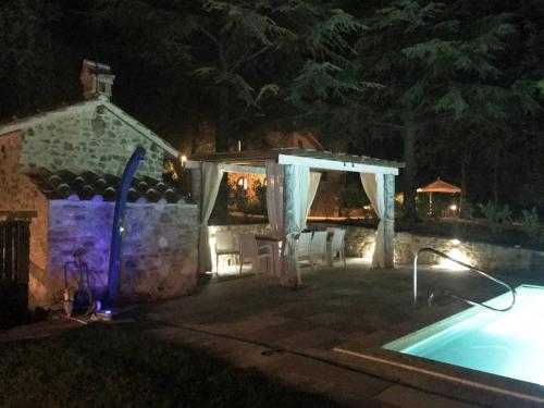 a swimming pool at night with a gazebo at Poggio Cantarello Country Home - Tuscany in Chiusi