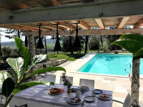 a table and chairs next to a swimming pool at Poggio Cantarello Country Home - Tuscany in Chiusi