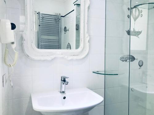 a white bathroom with a sink and a mirror at La Palladiana - Immobilevante in Ponza