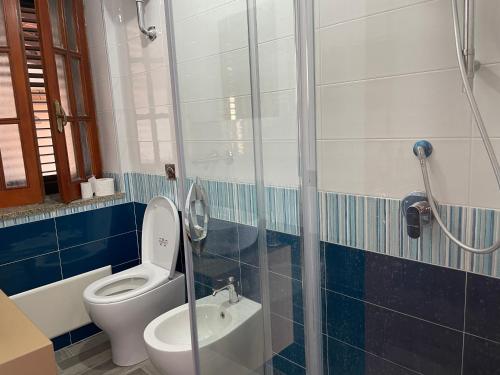 a bathroom with a toilet and a glass shower at Villa mare panoramica Estia in Brancaleone Marina