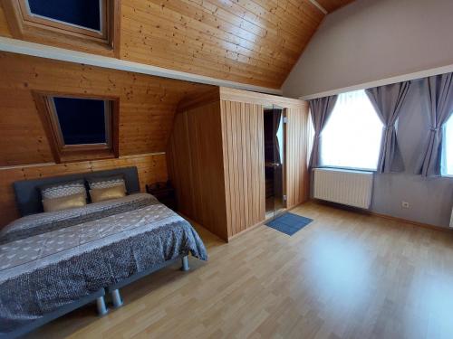 - une chambre avec un lit dans une pièce dotée de fenêtres dans l'établissement La Marilon, à Furnes