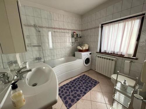 a bathroom with a tub and a sink and a toilet at Apartment Tody's in Fužine