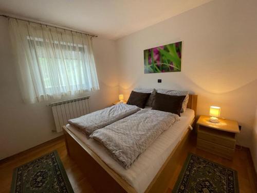 a bedroom with a large bed with two lamps at Apartment Tody's in Fužine