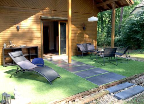 a patio with chairs and a table on grass at Wald und Wohlsein in Beelitz