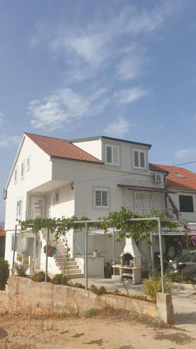 a white house with a fence in front of it at Jelsa Blue Sea View in Jelsa